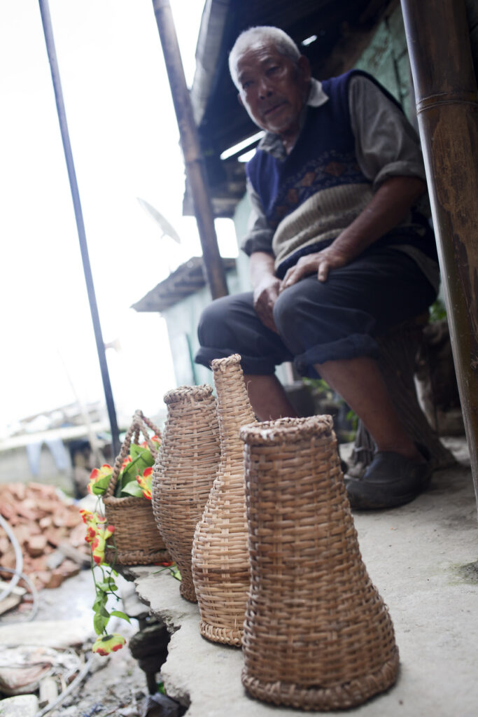 The old craftsman with his finished bamboo products, in Budang village, Central Pendam, East Sikkim.